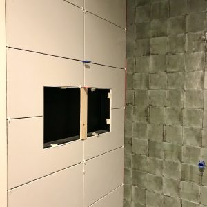 Tegelwerk badkamer met koof en voegloze tegels op achterwand